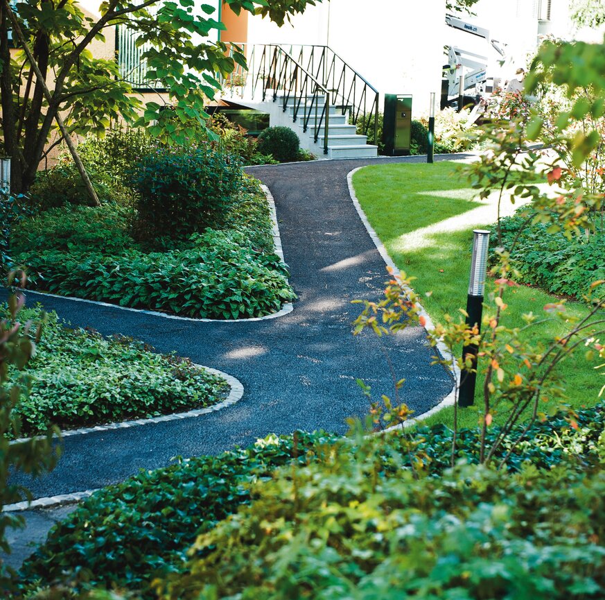Asphaltierte Wegführung in Rasenfläche